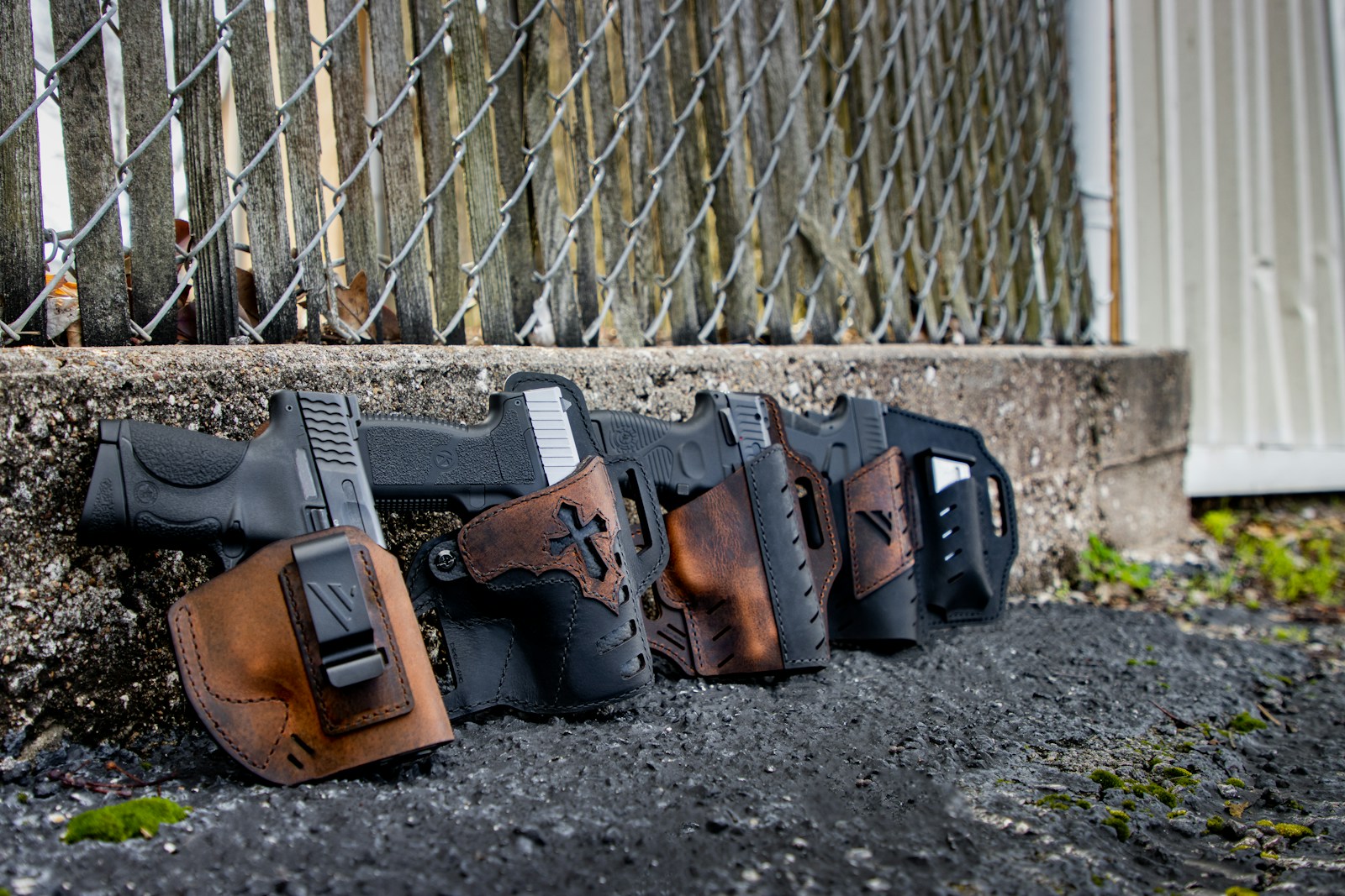 taiki-ishikawa-w6EMxsk8CDA-unsplash a row of holsters on the ground behind a chain link fence
