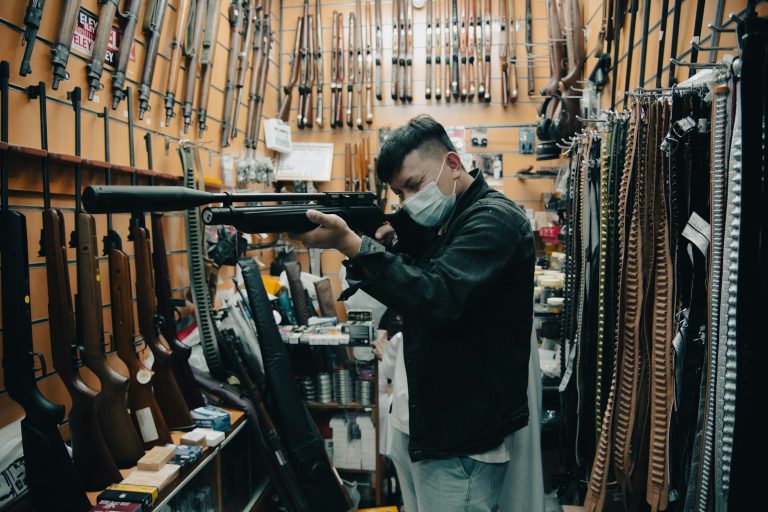 a man wearing a face mask holding a rifle