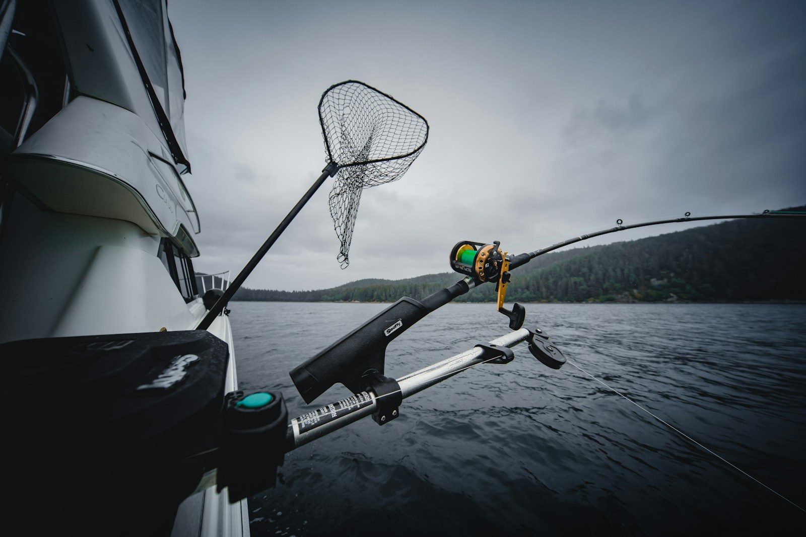 fishing rod and net hanging from a boat in the sea