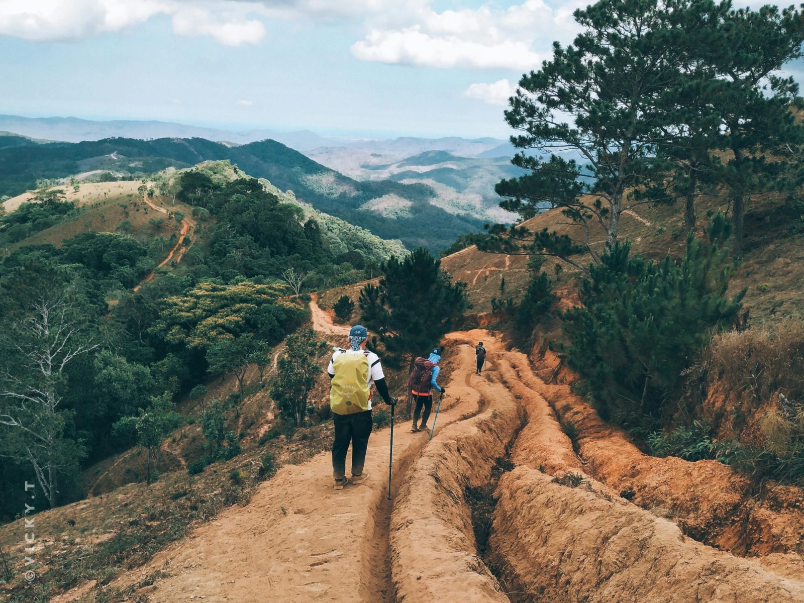 taiki-ishikawa-w6EMxsk8CDA-unsplash Back view of unrecognizable hikers with trekking poles traveling in green hilly valley