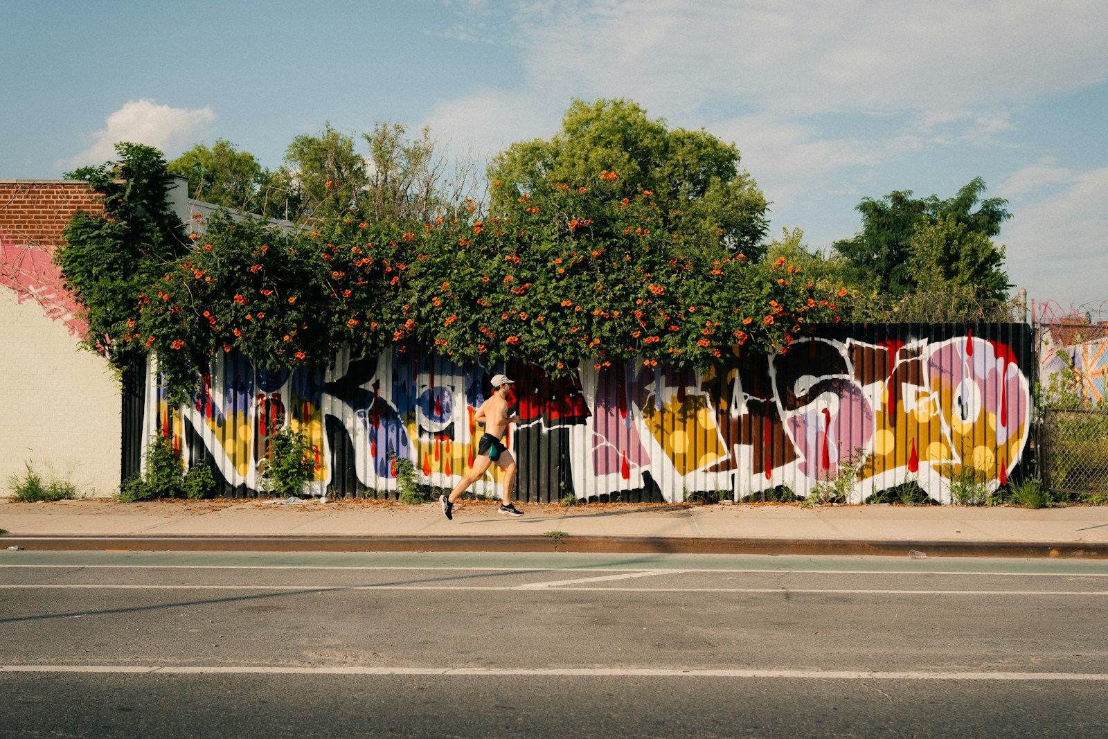 A wall covered in graffiti next to a street