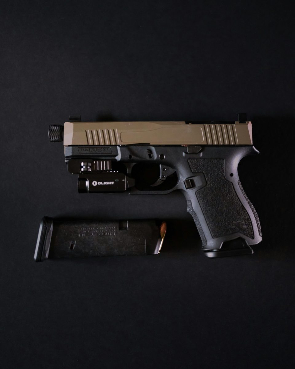 Detailed close-up of a handgun with magazine on a dark background emphasizing design and mechanics.