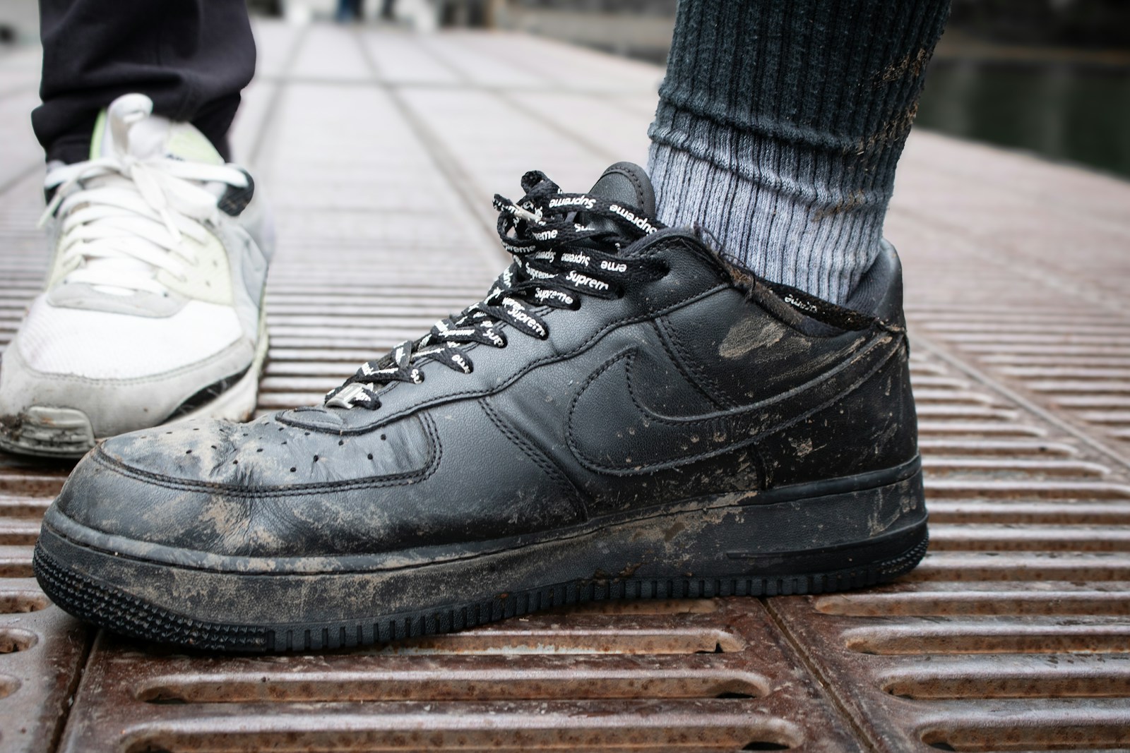 A pair of feet in black and white sneakers